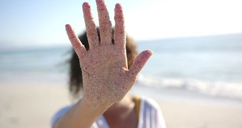 Sandy Hand Obscures Face at Sunlit Beach - Download Free Stock Images Pikwizard.com
