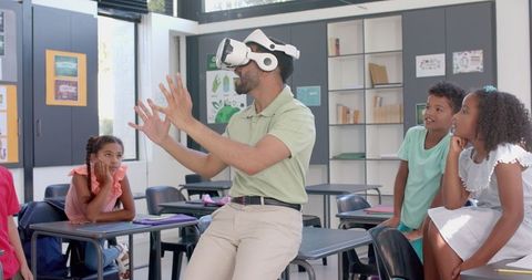 Teacher Uses VR Headset in Classroom With Curious Students Observing