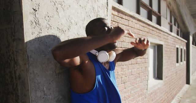 Man Relaxing Against Wall with Headphones on Neck - Download Free Stock Images Pikwizard.com