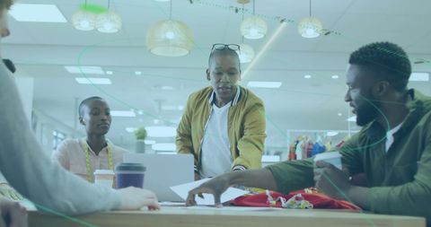 Diverse Fashion Designers Discuss Creative Ideas in Modern Workspace