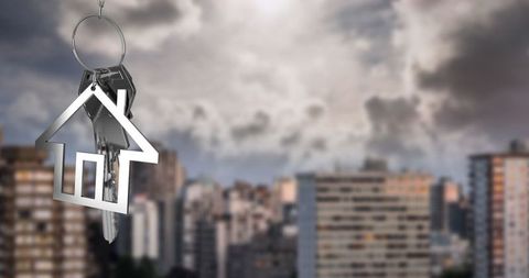 House-Shaped Keychain Above Urban Skyline Signifying Real Estate Concepts