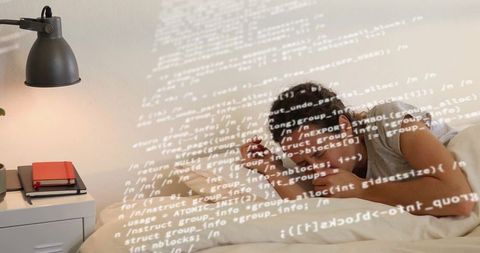 Woman in bedroom reviewing projected code on mobile workspace
