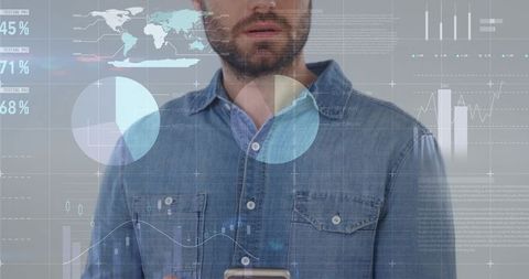 Holding smartphone and analyzing global data visualization with overlay charts and graphs