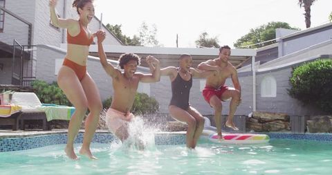 Joyful Friends Jumping into Swimming Pool Together