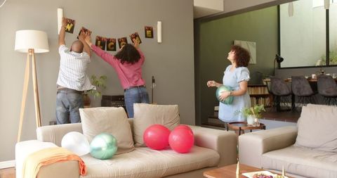 Friends Decorating Cozy Living Room for Welcoming Party Celebration