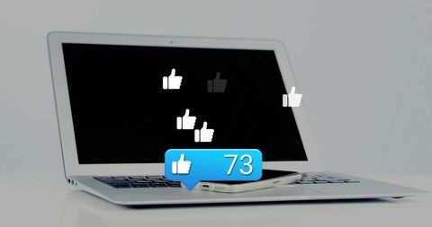 Minimalist laptop and smartphone showing social media likes with 73 engagement notification