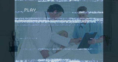 Doctors Consulting with Patient in Hospital Room