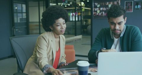 Colleagues collaborating on creative project in modern workspace