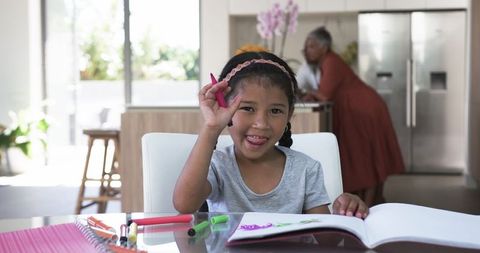 Joyful Girl Doing Homework in Bright Family Kitchen - Download Free Stock Images Pikwizard.com