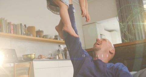 Happy Father Holding Daughter in Sunlit Home