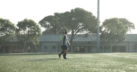 Referee supervising soccer match on sunny day