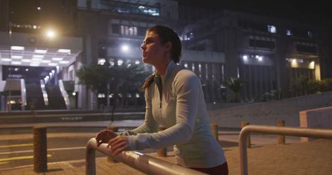 Fit woman doing night exercise in urban environment
