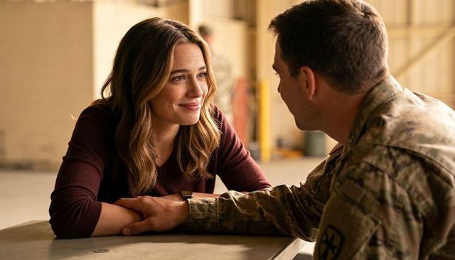 Emotional reunion between soldier and partner holding hands in airfield hangar intimate moment