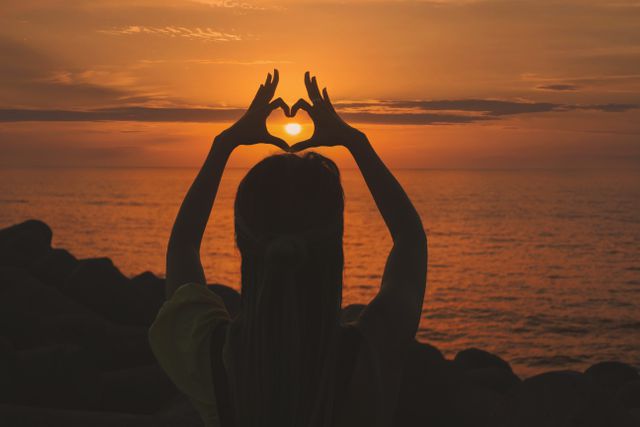 Silhouette of Woman Making Heart Shape with Hands During Sunset - Download Free Stock Photos Pikwizard.com
