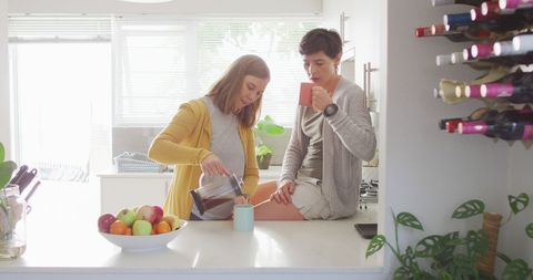 Lesbian Couple Enjoying Morning Coffee in Sunlit Kitchen