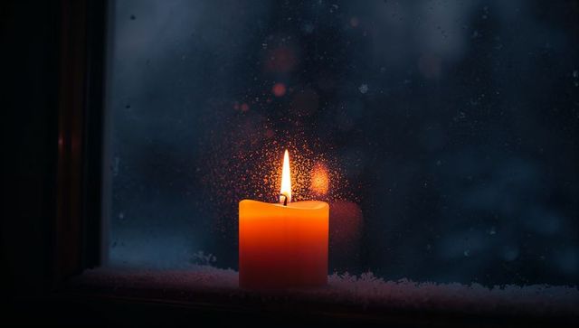 Cozy Glow of Candlelight on Frosted Window