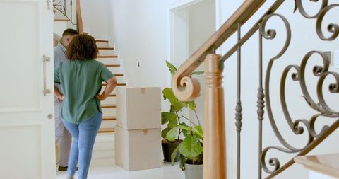 African american couple unpacking boxes in modern home entryway