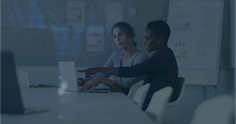 Women Collaborating in Modern Office Brainsorming Over Laptop with Charts