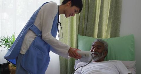 Caring Doctor Checking Blood Pressure of Senior Patient in Retirement Home