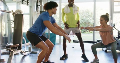 Young Adults Enjoying Workout Session with Trainer in Modern Gym