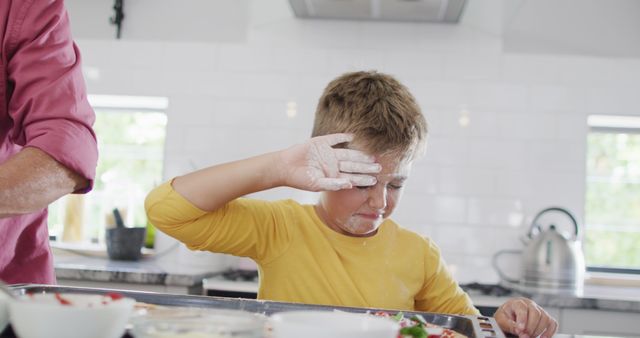 Child Wiping Flour from Face in Bright Kitchen - Download Free Stock Images Pikwizard.com