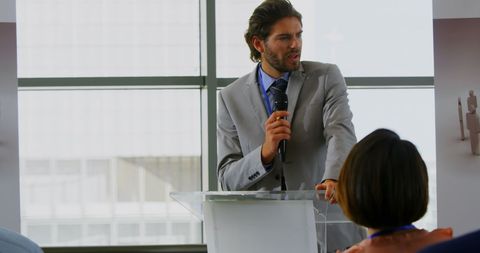 Businessman speaking at podium during seminar presentation