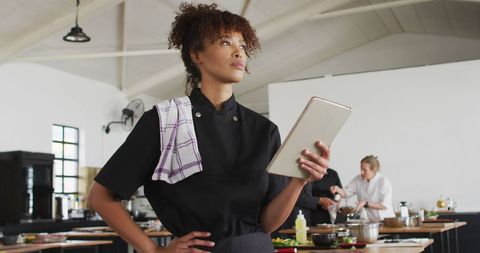 Chef Standing in Commercial Kitchen Using Tablet