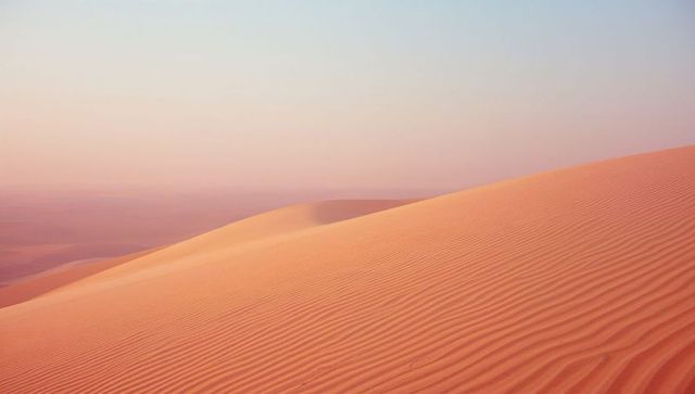 Majestic Desert Dunes Amidst Serene Pastel Horizon