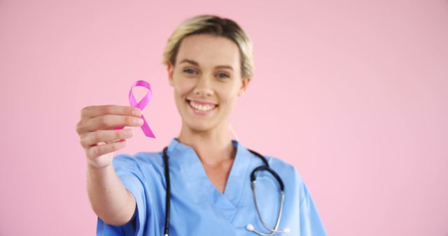 Smiling Nurse Holding Pink Ribbon for Breast Cancer Awareness - Download Free Stock Images Pikwizard.com