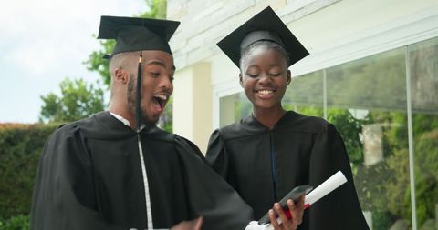Graduates Celebrating Achievement Outside with Smiles and Joy