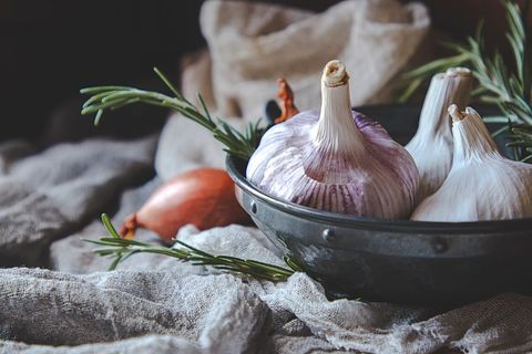 Rustic Garlic and Rosemary Composition in Metal Bowl on Linen Cloth for Culinary Use