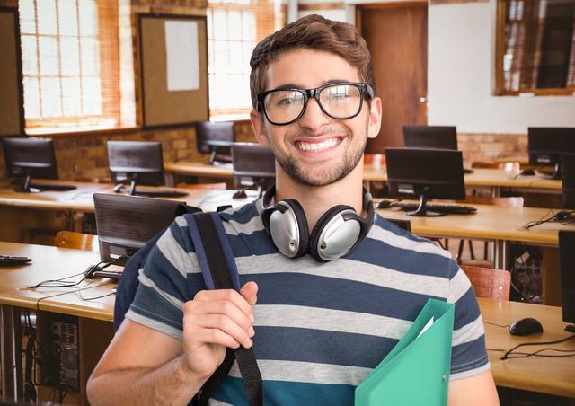 Smiling teenage student standing in a classroom, wearing glasses and headphones around neck, holding a folder. Ideal for educational materials, school promotions, academic websites, and back-to-school campaigns.