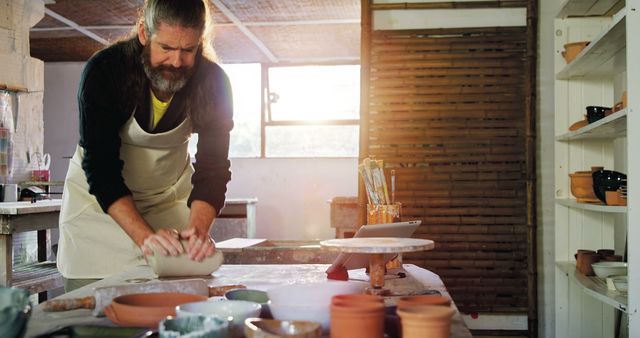 Mature Pottery Artist Working in Studio with Warm Sunlight - Download Free Stock Images Pikwizard.com