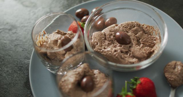 Image of chocolate pudding with chocolate eggs and strawberries on a black surface. party food and savoury snacks.