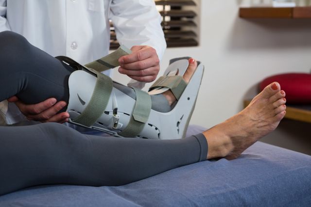 Physiotherapist tying leg pad - Download Free Stock Photos Pikwizard.com