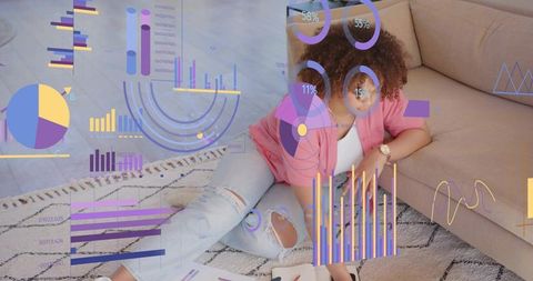 Woman reclining on rug reviewing papers with colorful data visualization overlays at home
