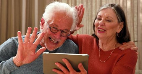 Senior Couple Enjoying Digital Device Interaction in Comfortable Home