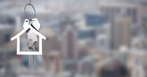 House-Shaped Keychain with Keys on Cityscape Background