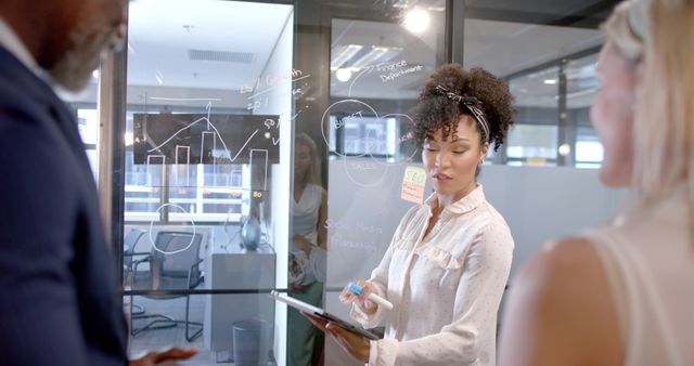 Confident Businesswoman Presenting Financial Data on Glass Board - Download Free Stock Images Pikwizard.com