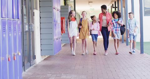 Diverse Teacher Walking with Happy Students in School - Download Free Stock Images Pikwizard.com