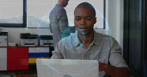Black professional typing on laptop with holographic globe for digital collaboration