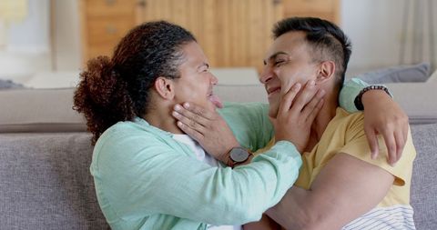Playful Diverse Gay Couple Enjoying Time on Sofa