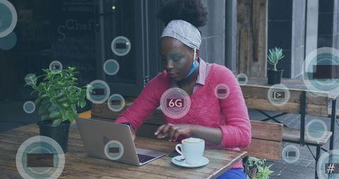 African American Woman Using Laptop with 6G Digital Interface Outdoors