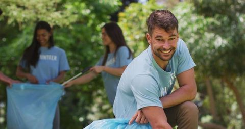 Joyful Volunteers Collect Rubbish in Scenic Park Clean-Up Drive