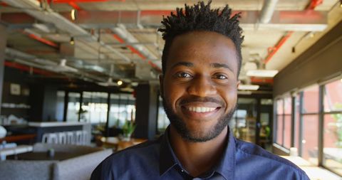 Confident Young Businessman Smiling in Modern Office Setting