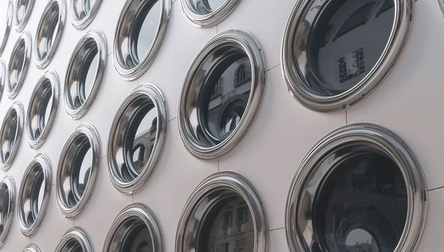 Reflecting porthole window facade with chrome bezels and urban architecture reflections