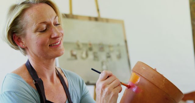 Woman Painting Terra Cotta Pot with Brush in Art Studio - Download Free Stock Images Pikwizard.com