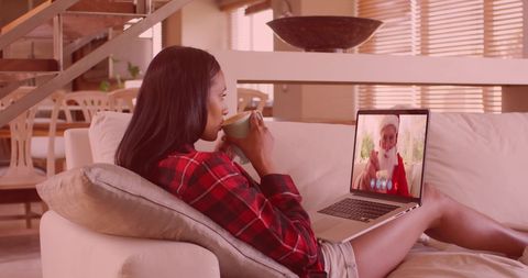 Young woman video calling santa claus for christmas holiday cheer