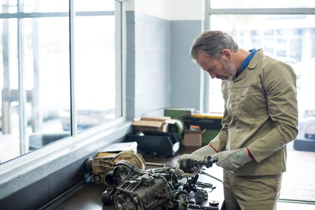 Mechanic checking a car parts in repair shop