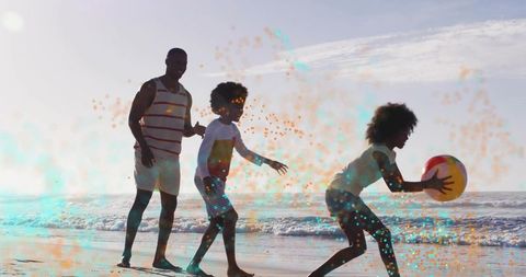Backlit family playing with colorful beach ball on sunlit wet shore, joyful summer fun